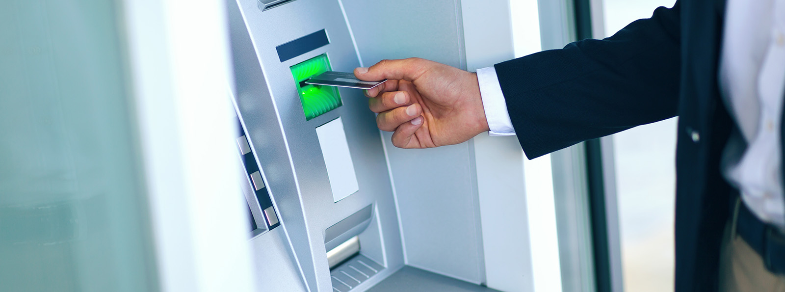 a man puts his card into a Sovita ATM machine