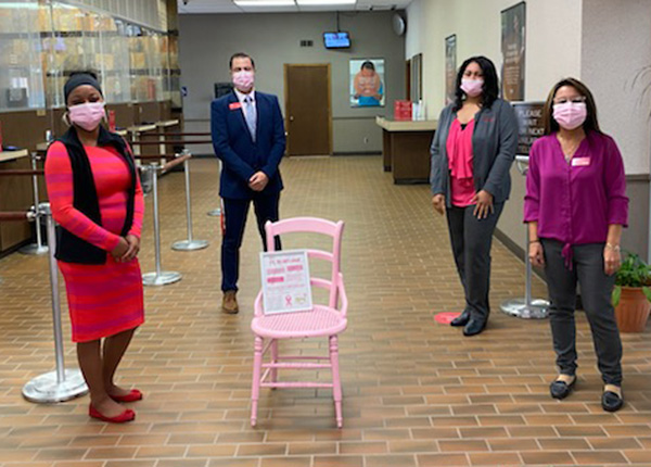 four sovita credit union members standing around a pink chair