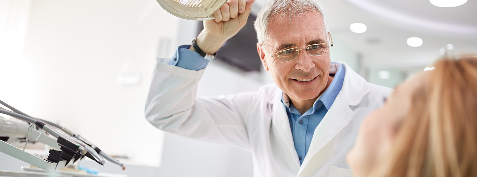 a dentist sits with a patient and smiles