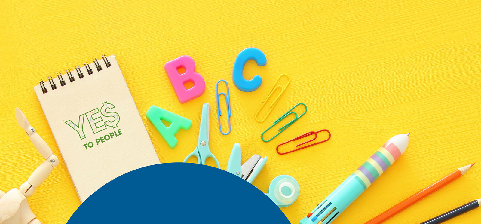 colorful school supplies including a notepad that says YES To People on it, all laying on a bright yellow background